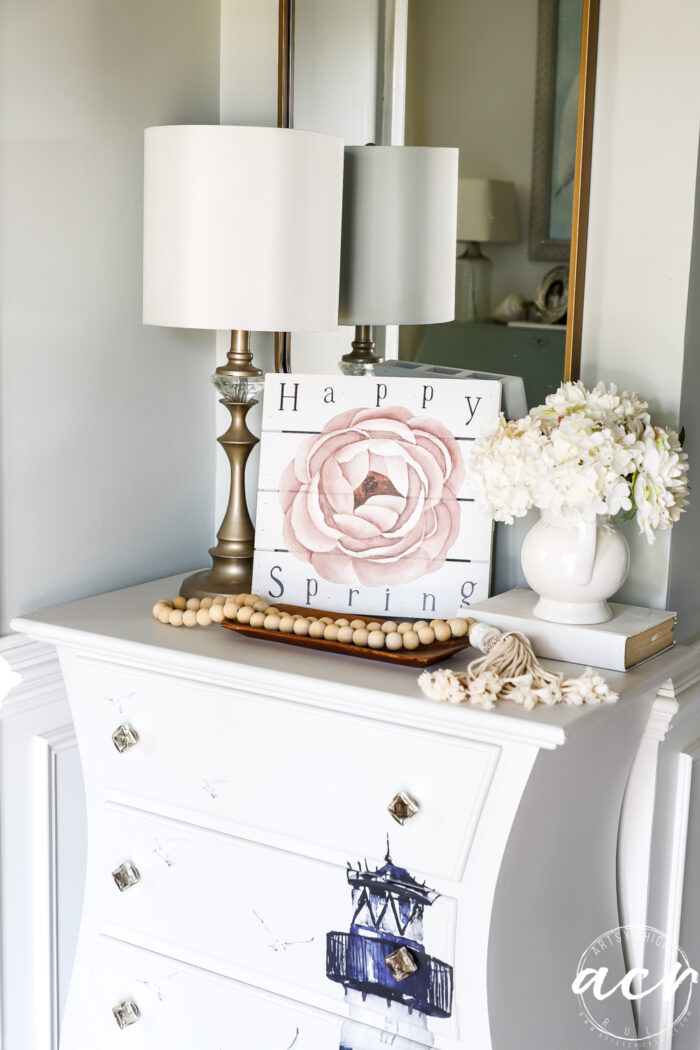 happy spring sign on white chest in foyer