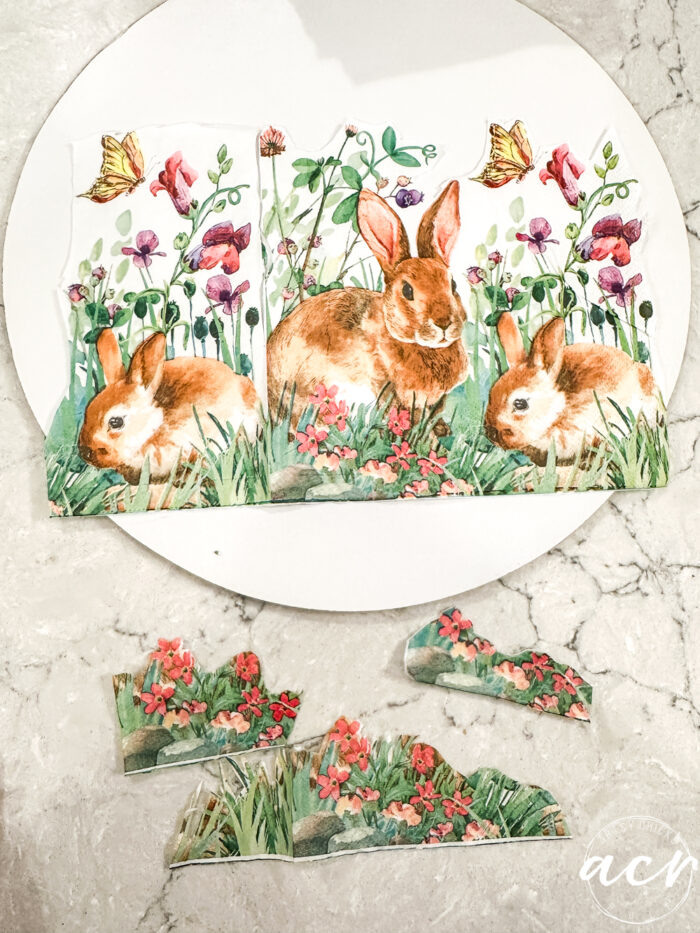 bunnies in the grass napkin on white round sign