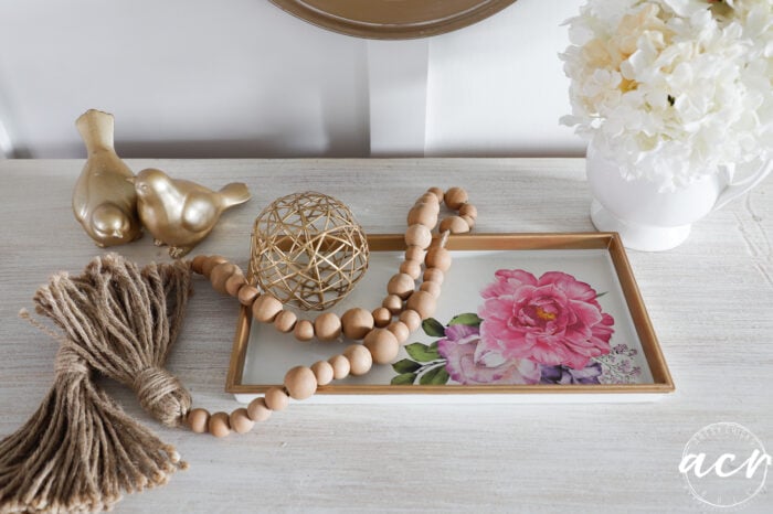 gold and white tray decorated on dresser