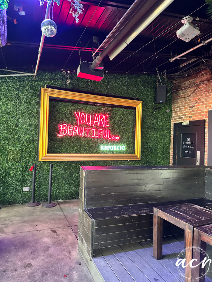 greenery wall with framed you are beautiful neon sign