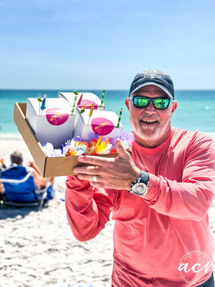 man holding drinks on the beach