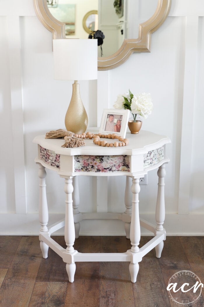 table styled with gold lamp, photo and flowers