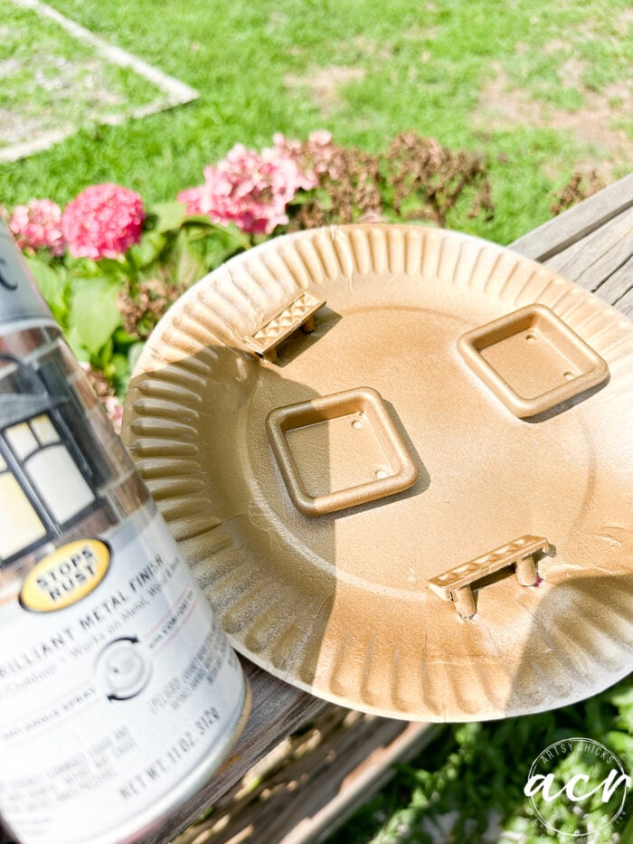 paper plate in the sun with hardware that has been spray painted