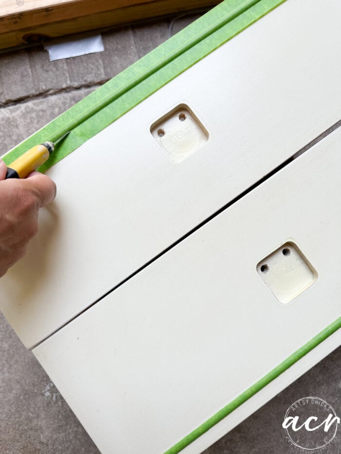 taping the gold strips on drawer fronts