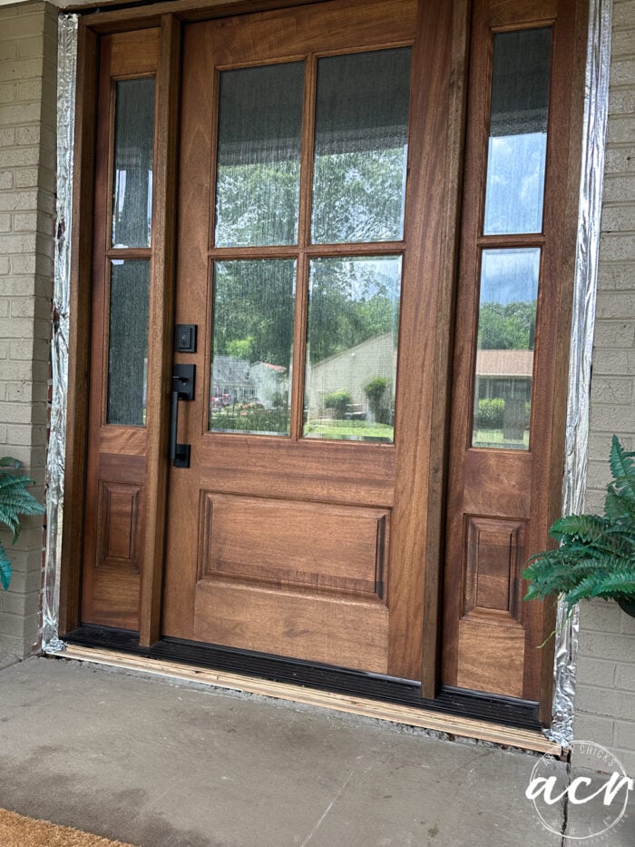 wood front door with window film applied