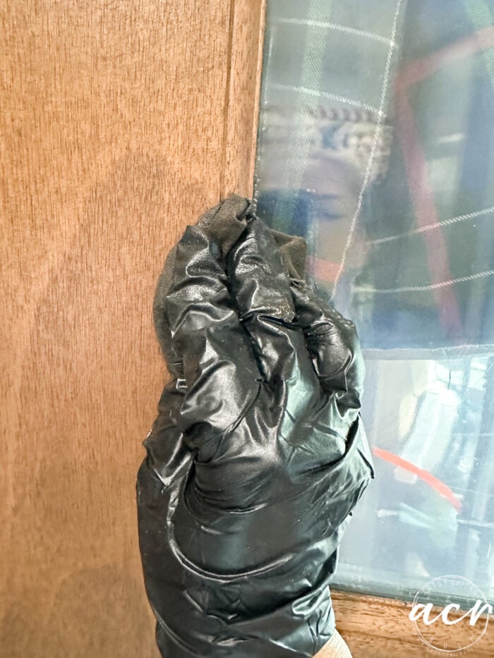 applying stain with glove