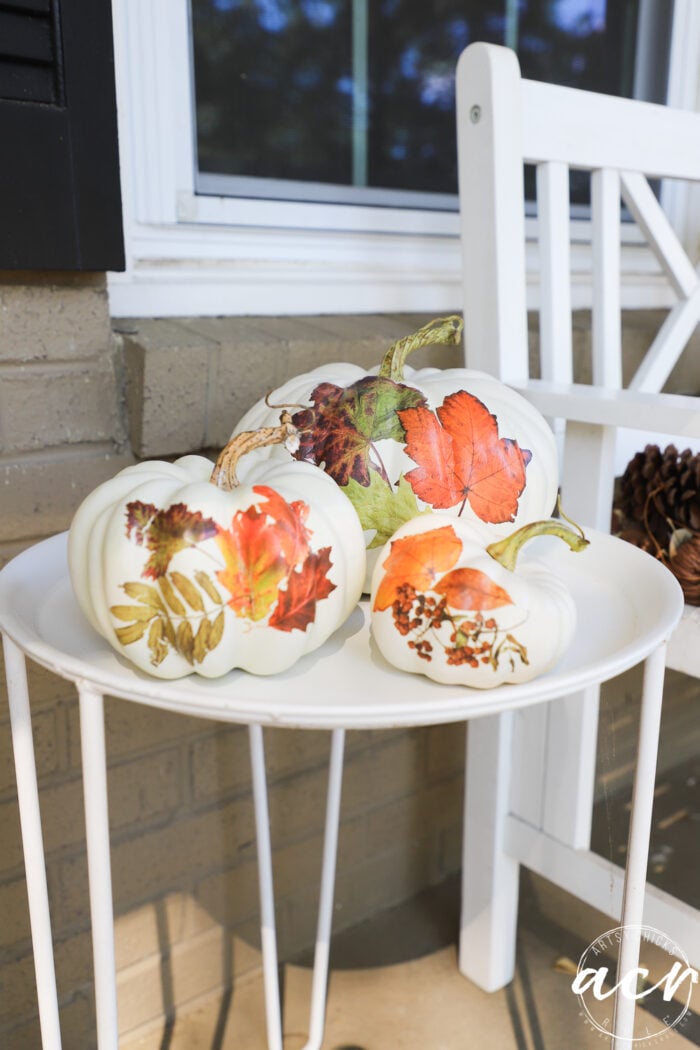 white pumpkins with orange leaf transfers on white table