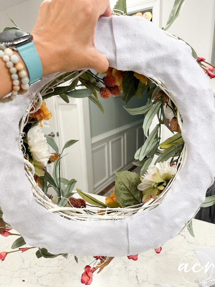 holding up the wreath to show the back