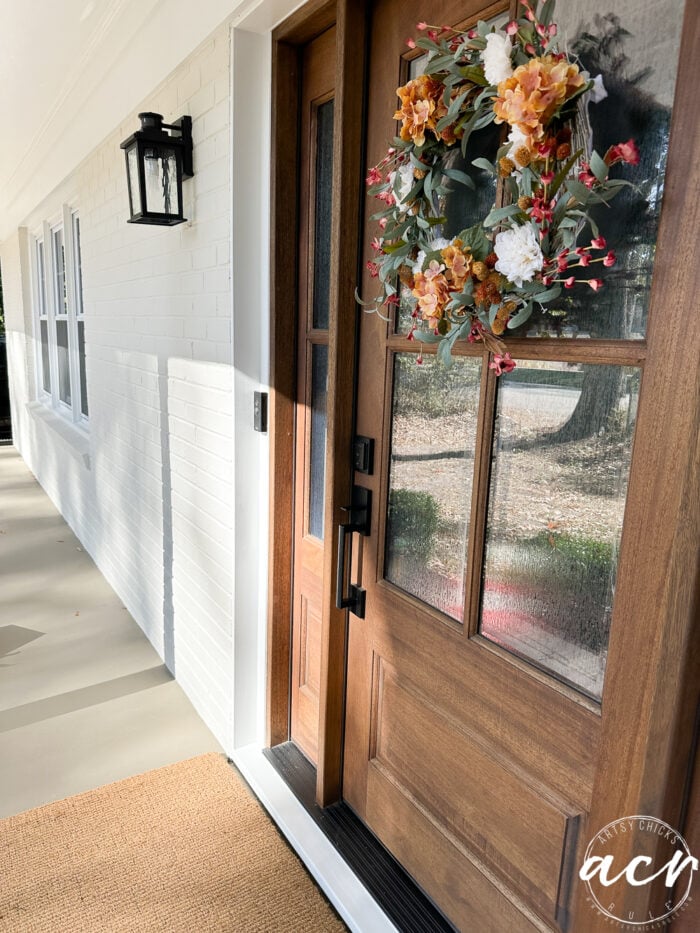 wood front door with warm white house and black light