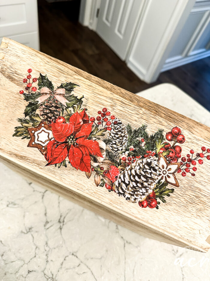 the finished wood box/tray collage with all the additions, pine cones, red berries, greenery and poinsettias