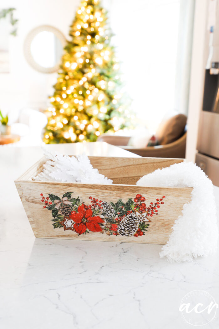 lighted christmas tree in back with wood and poinsettia tray on counter