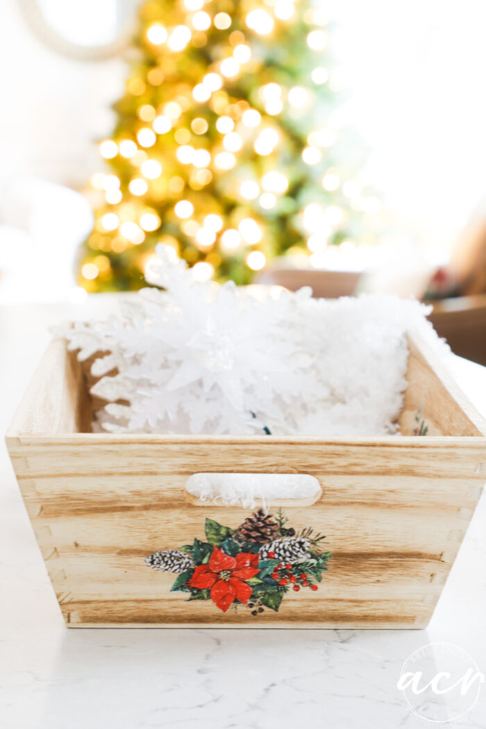 wood tray on counter with lighted christmas tree in background