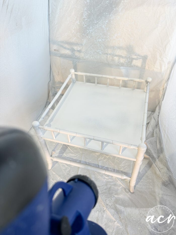 table being sprayed white in spray tent