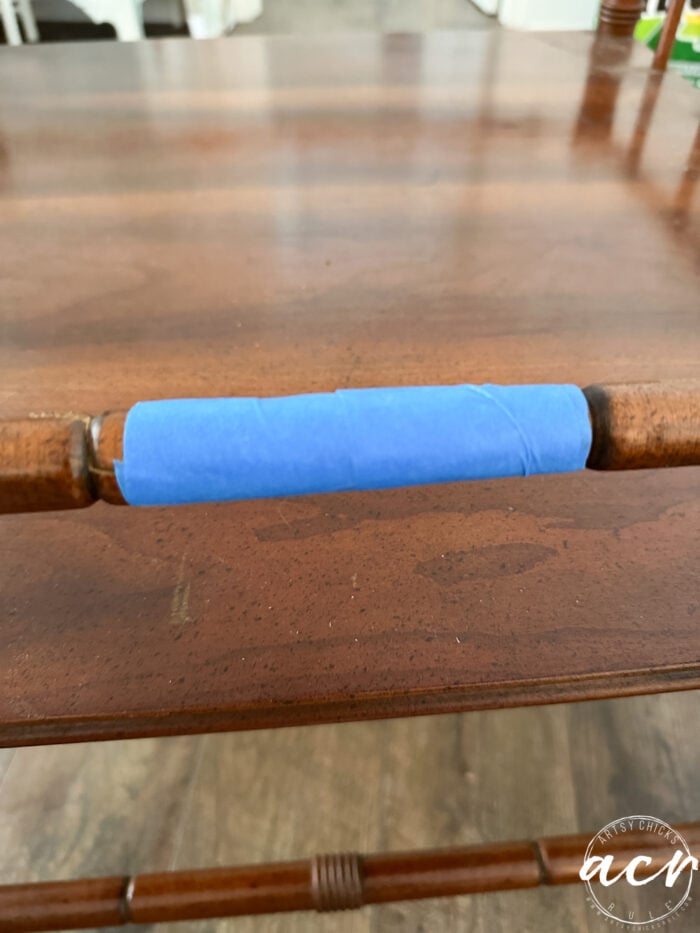 wood table with blue tape around it
