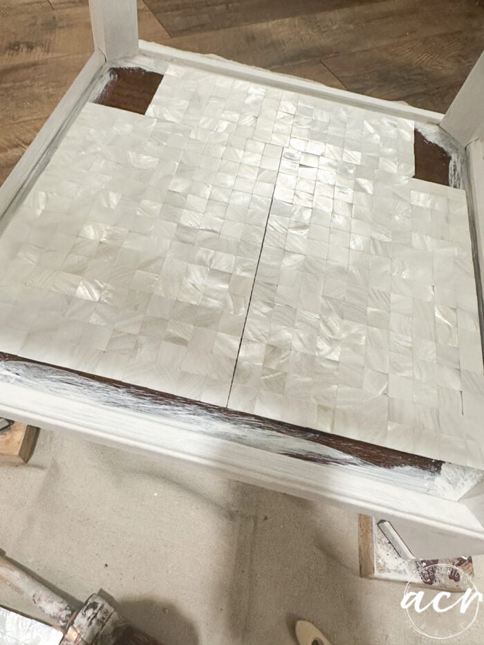 Se encuentran mosaicos en el estante inferior