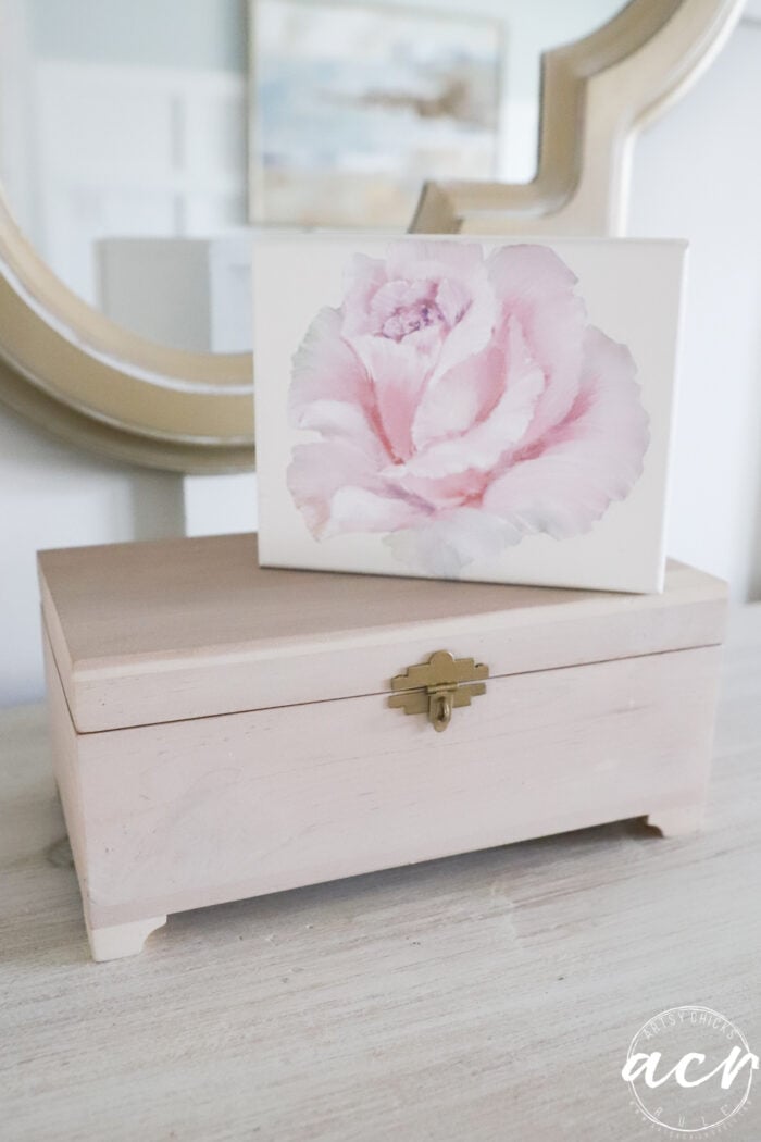 pink rose white box on top of stained cedar box