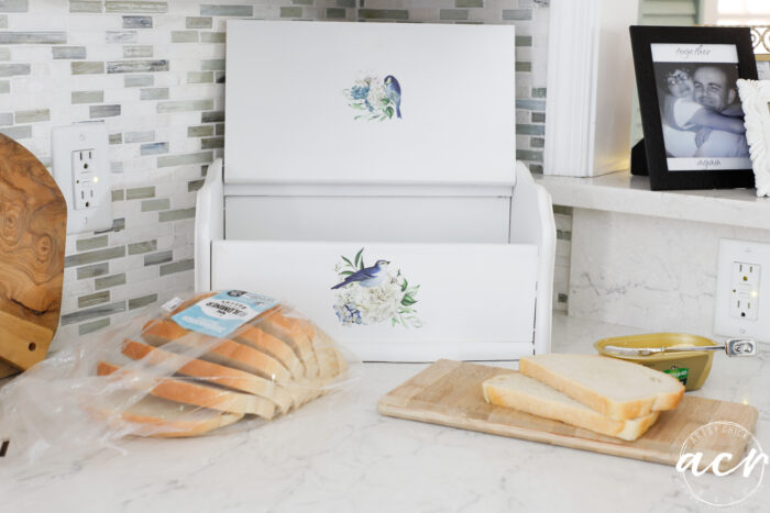 bread on the counter in front of open bread box
