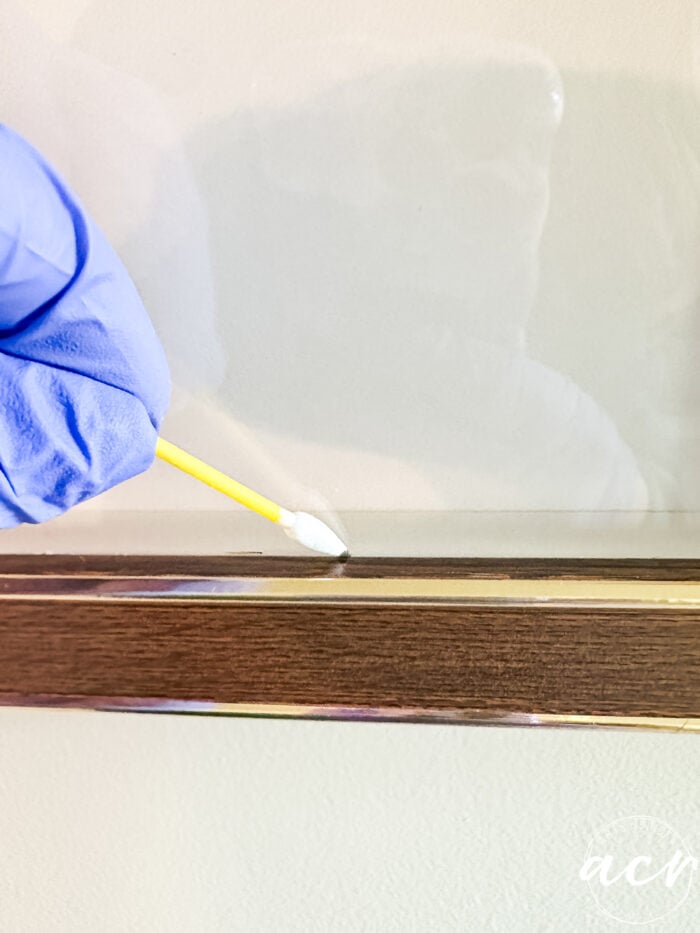 wiping away the excess on glass with qtip