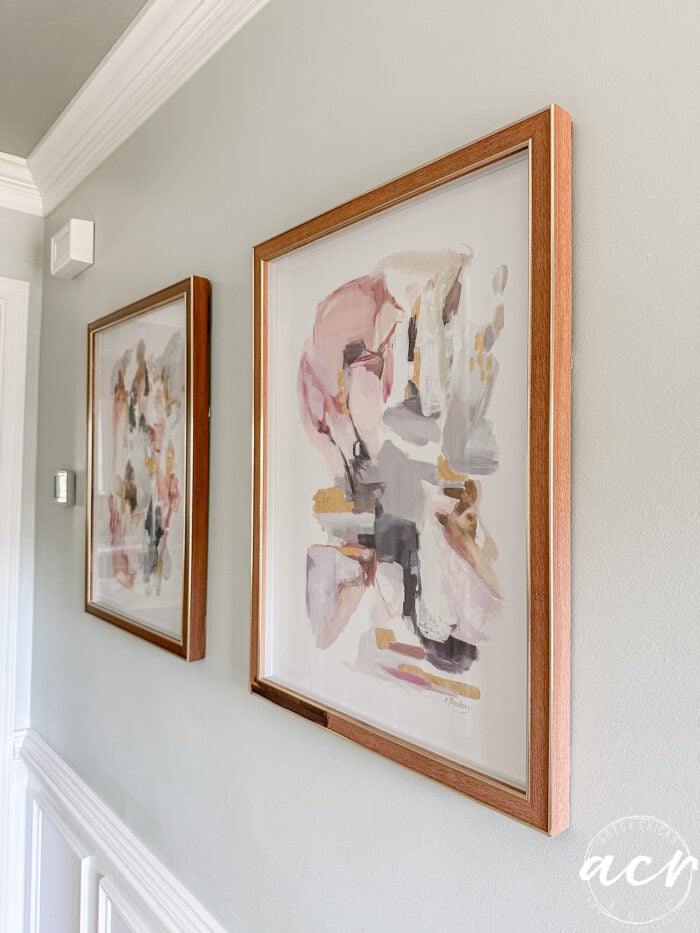 different view of prints on the wall with one done and one just started staining