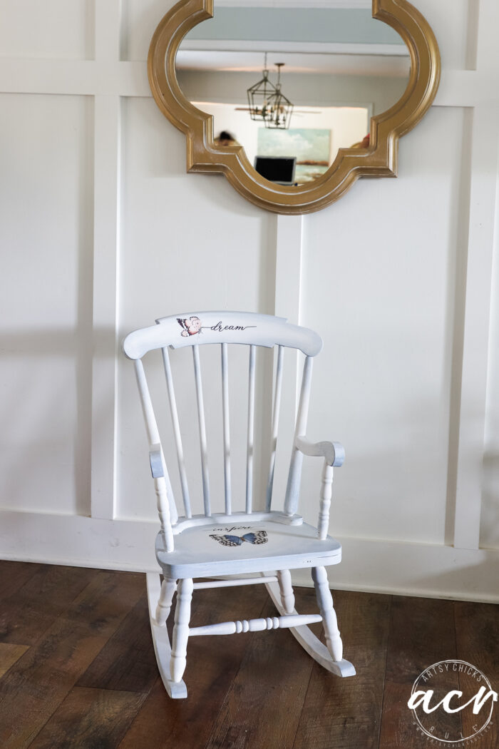 finished rocker against white wall under gold mirror