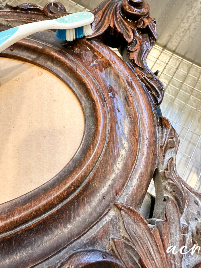 using toothbrush to clean wood frame