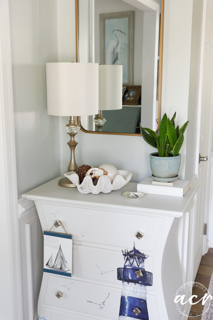 hanging art hanging on small white chest in foyer