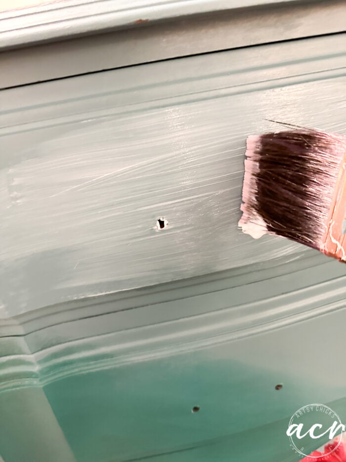 applying decoupage gel to the front of the nightstand