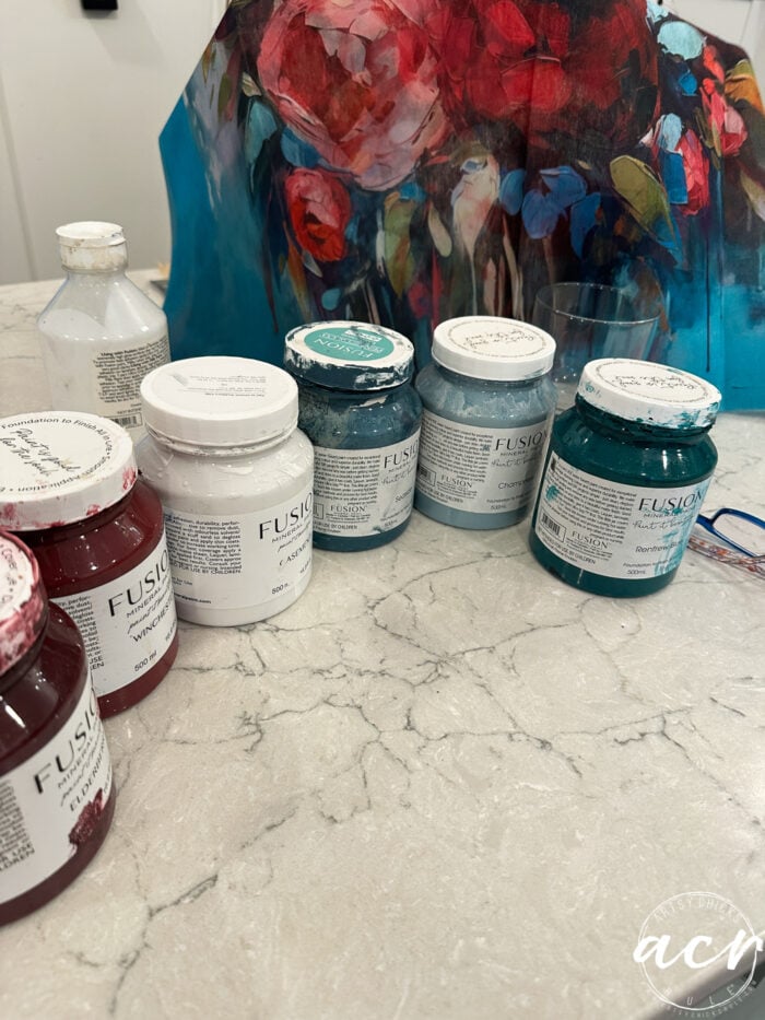 several jars of paint on countertop