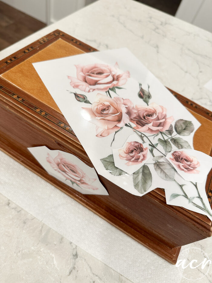 wood box with pink rose transfers laying on top