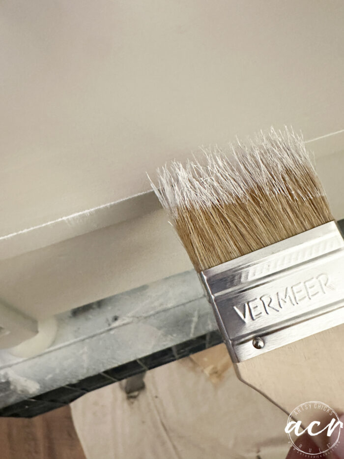 brushing edges of table with chip brush and white paint