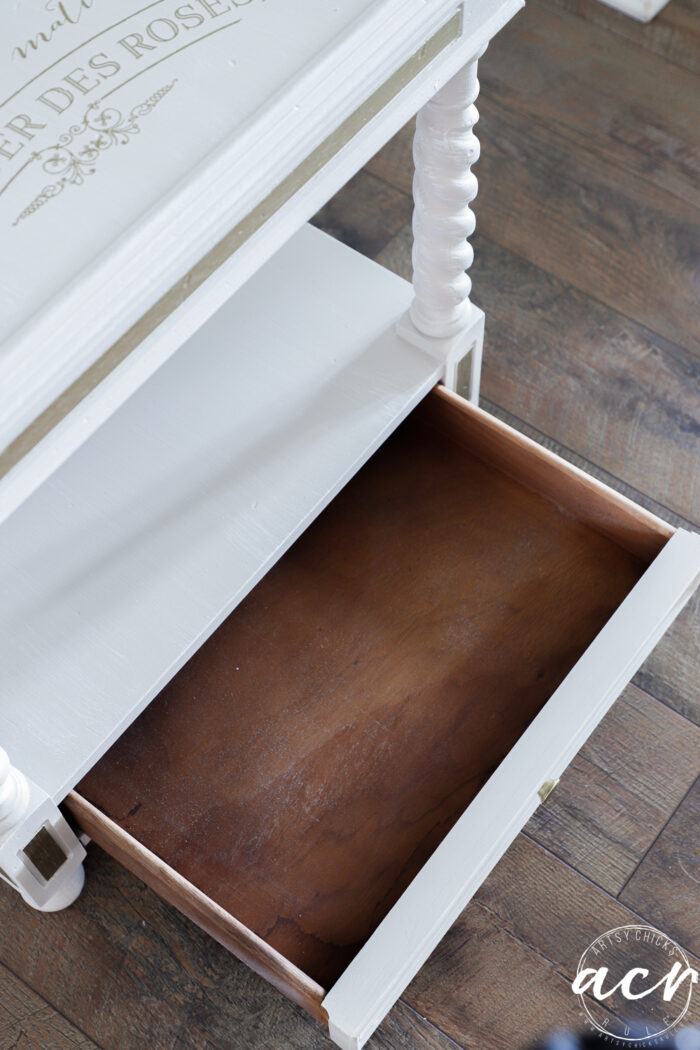 bottom drawer of table open showing natural wood inside