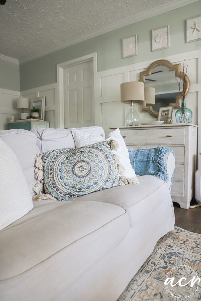 tan couch wwith blue and aqua decor pillow