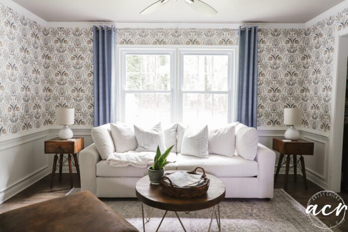 white couch with blue curtains and wallpaper