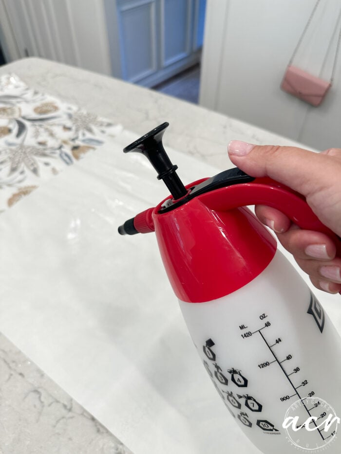 using sprayer to wet back of wallpaper