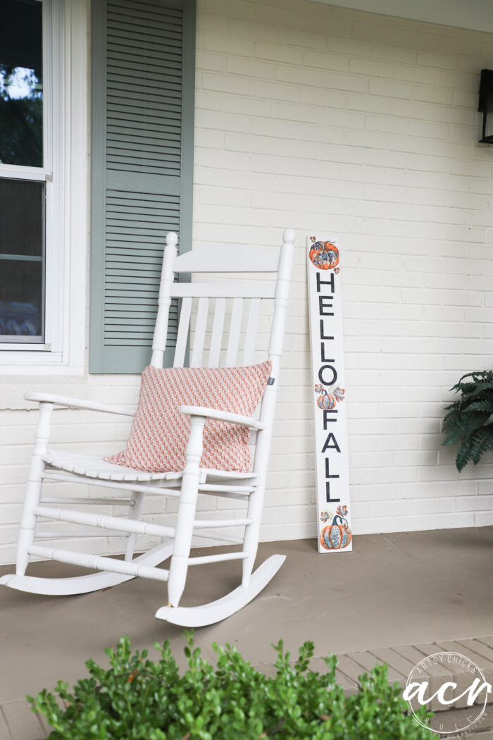white rocker on porch with hello fall sign with large block print