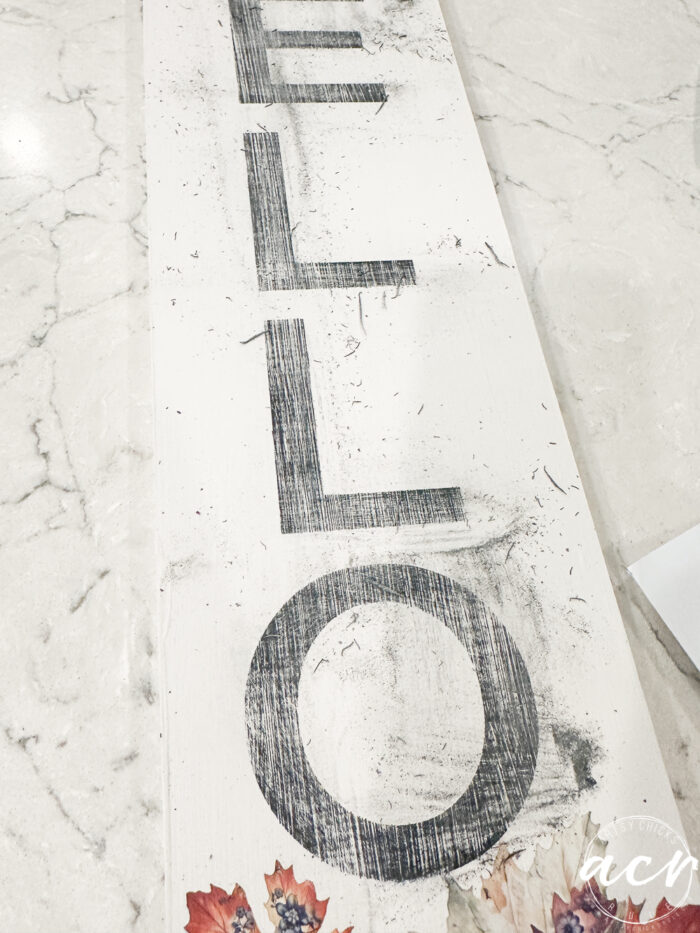 wood sign with black print sanded mostly off