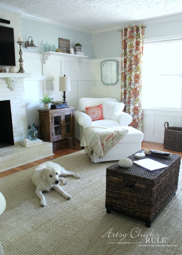 colorful curtains , white chair, light colored rug and white dog