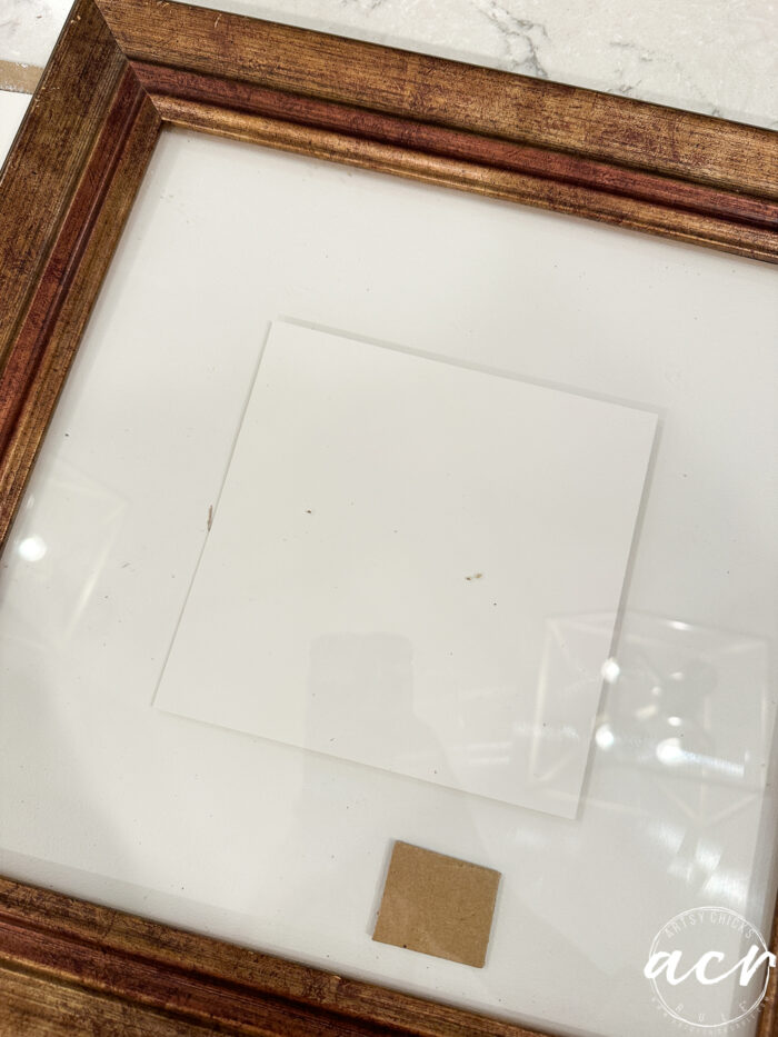 folder cut and painted print inside frame