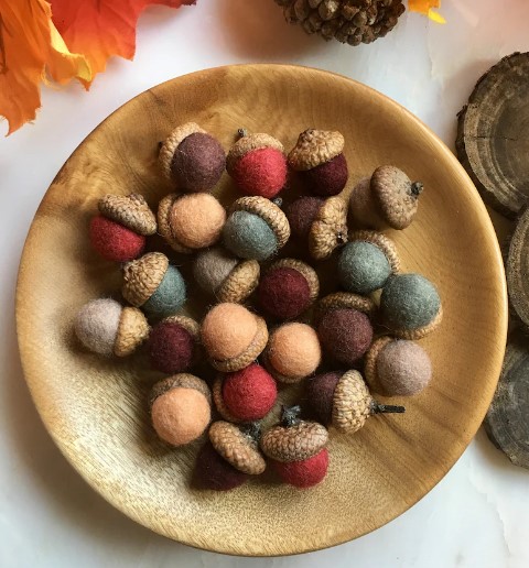 acorns made of fabric and real acorn tops in bowl