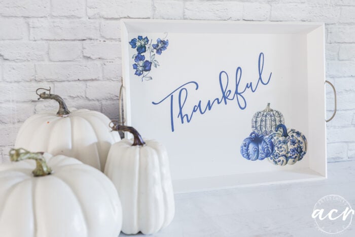 white pumpkins beside white tray with blue pumpkins and thankful