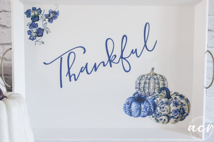 white pumpkins beside white tray with blue pumpkins and thankful