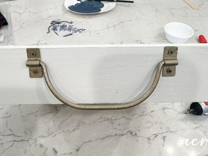 gold handle on one side of tray