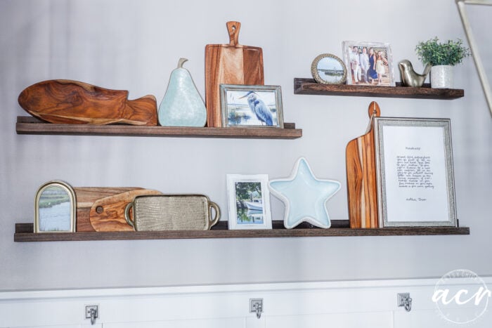 narrow wood shelves with cuttingboards, decor and framed pictures