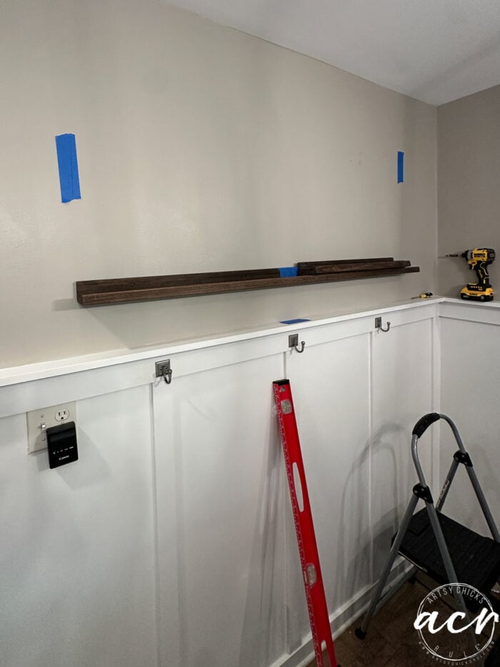 tape on the wall and one shelf hung