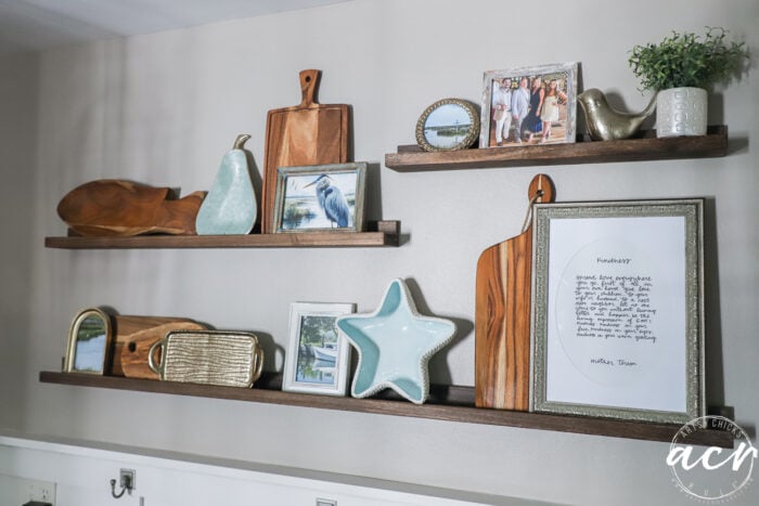 narrow ledge type shelves with cutting boards, framed prints and decor