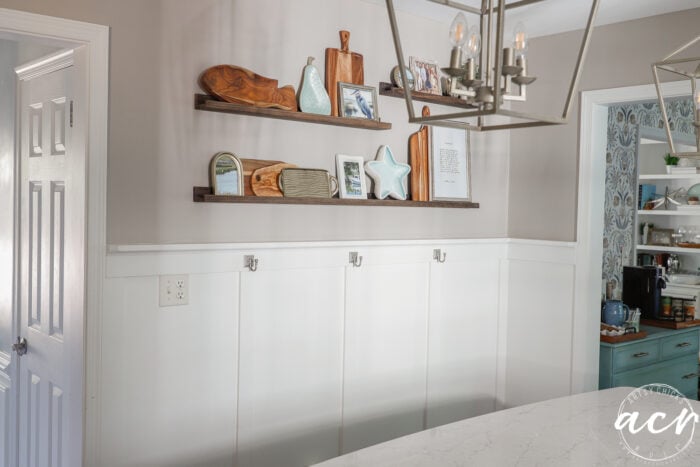 wood narrow shelves with various kitchen decor and framed prints