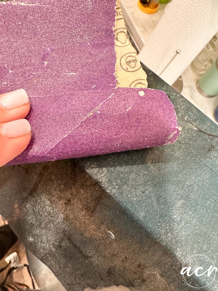 lightly sanding edges of box to "cut" tissue paper