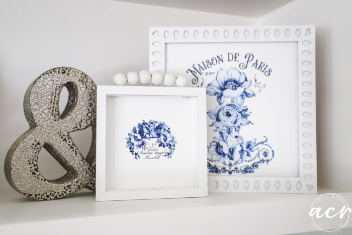 several framed art with silver decor grouping on shelf