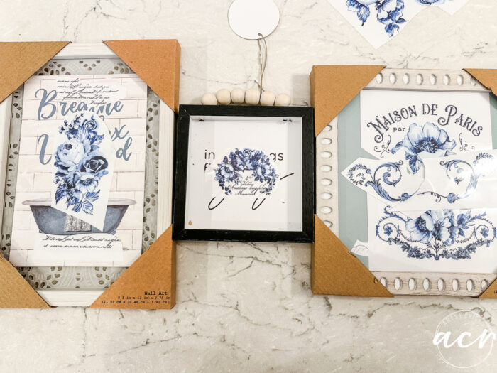 3 framed art laying on counter with transfers laying on them