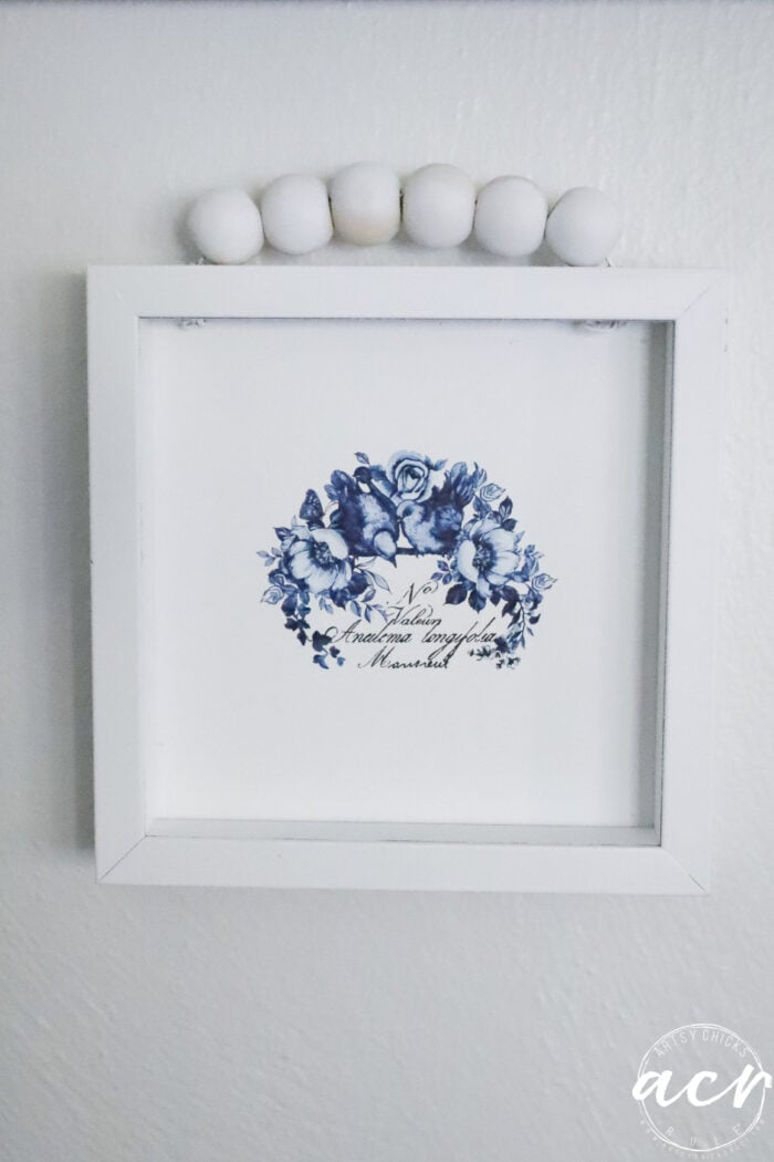 small blue and white framed art up close